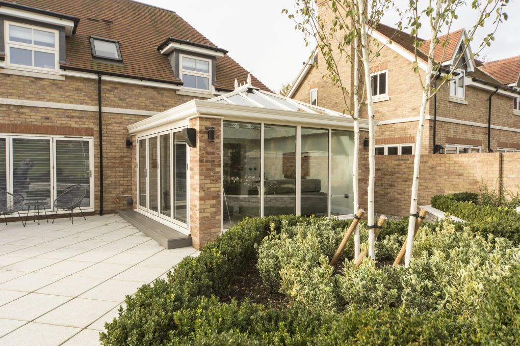 Refurbished conservatory with white roof and sand coloured brickwork
