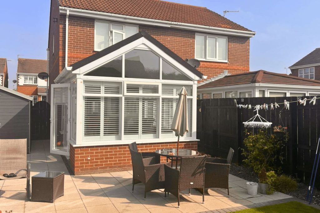 modern upvc conservatory in newcastle, with opened white upvc french doors on the side